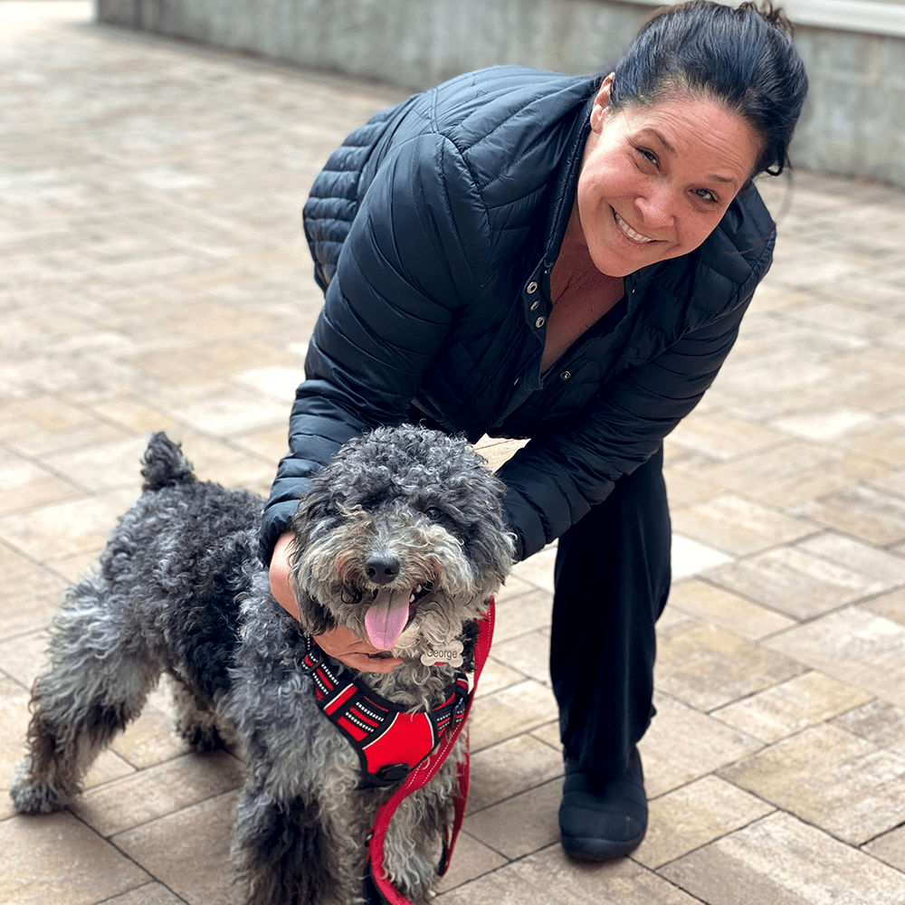 Lady wearing a black jacket while walking dog